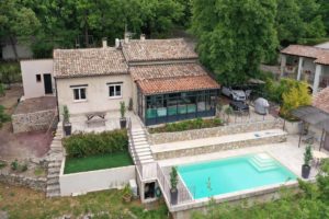 Cette image représente une villa à Peymeinade (Alpes Maritimes) prise par un drone. On voit clairement l'ensemble de la villa, la piscine au premier plan et une partie des espaces verts environnants